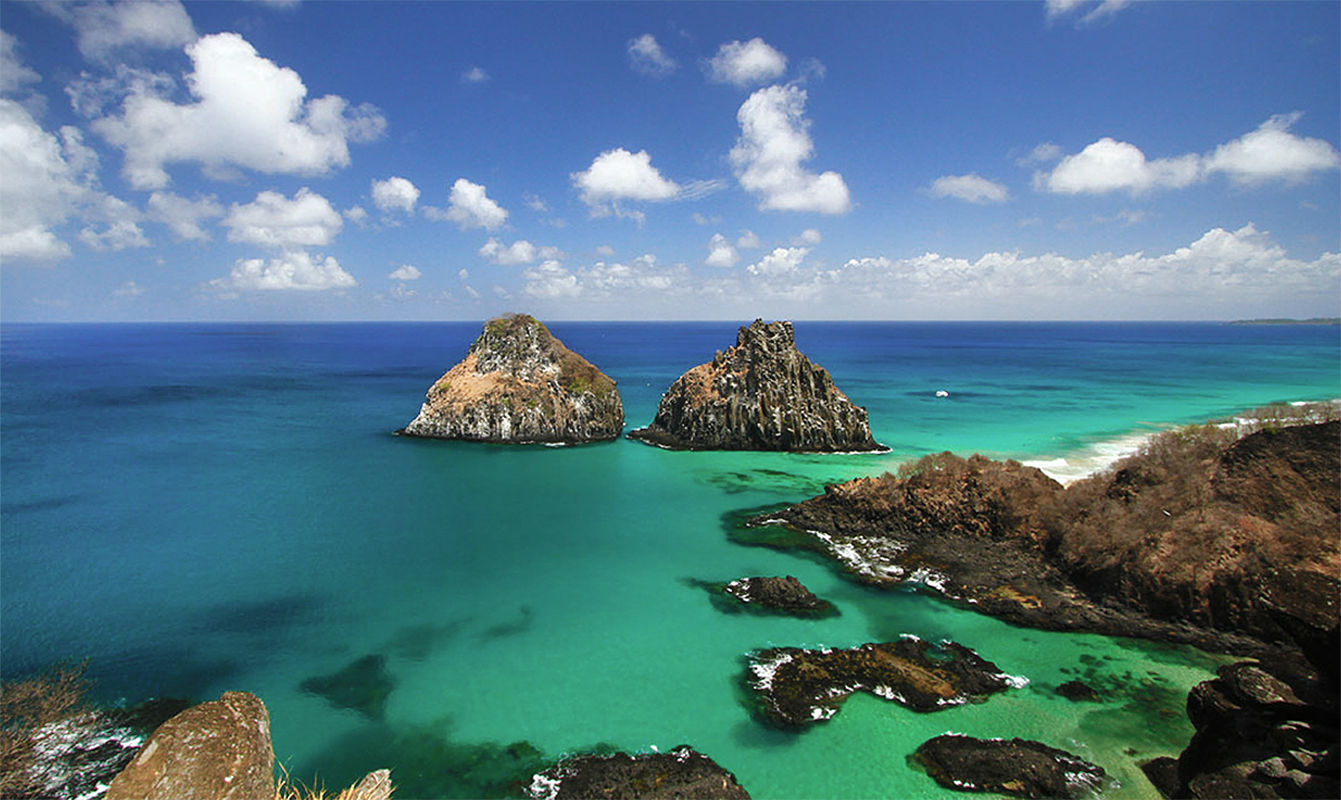 Bahia dos Porcos beach features the island&rsquo;s familiar twin peaks