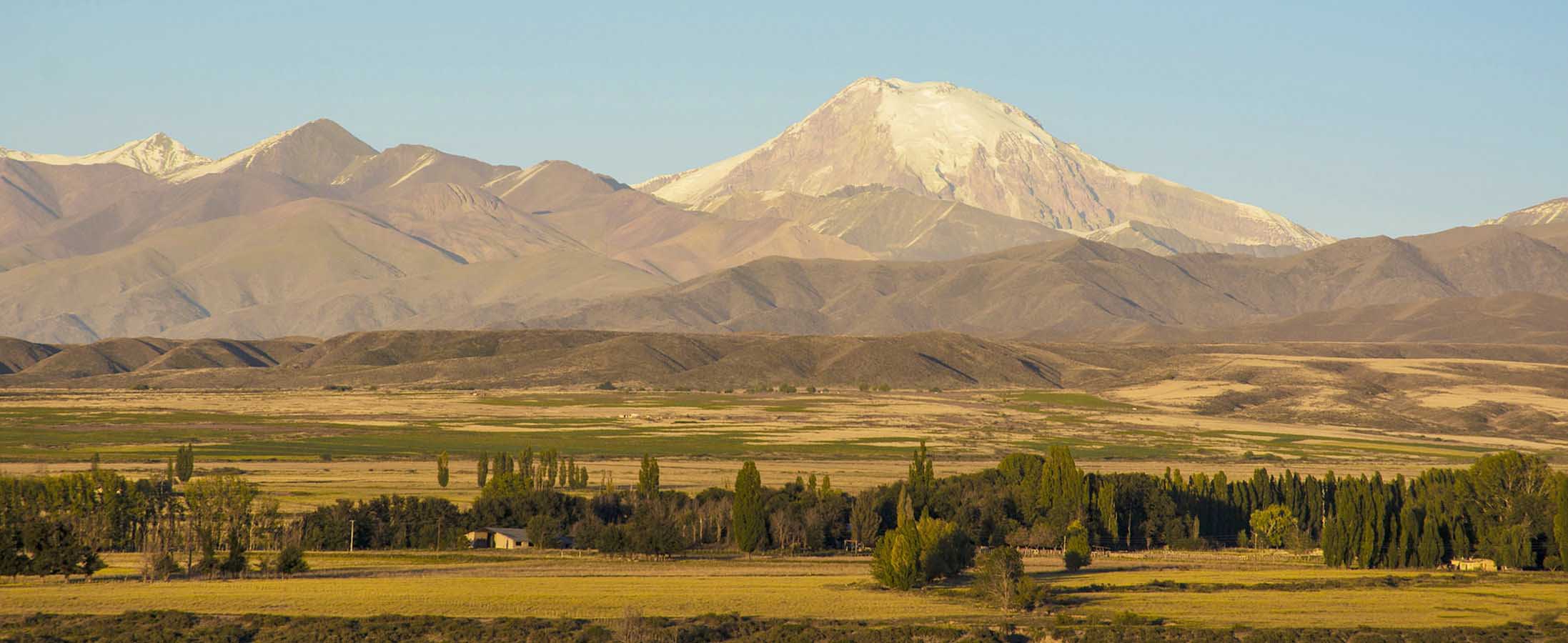 Views of the mountains and Uco Valley, imbued in hues of orange and green